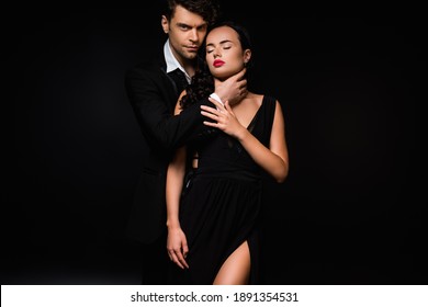 Passionate Man Choking Sexy And Submissive Woman In Dress Isolated On Black