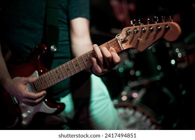 Passionate man strums guitar in a lively live music bar, creating an immersive and vibrant atmosphere. - Powered by Shutterstock