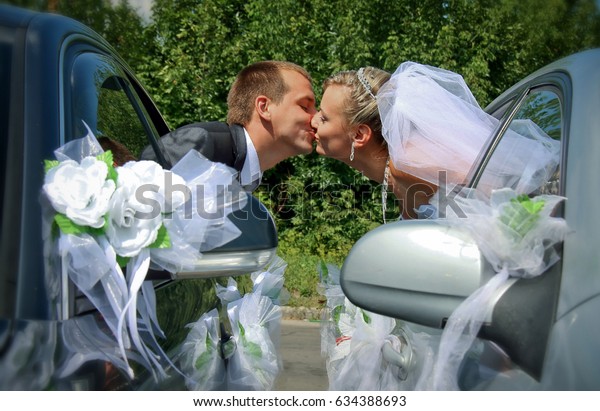 Passionate\
married couple kissing with car\
windows