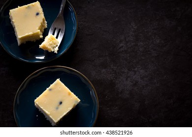 Passionfruit Slice On Plates From Above Dark Background With Copy Space