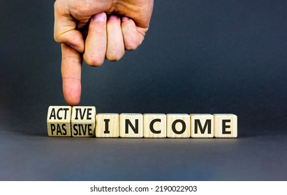 Passive or active income symbol. Businessman turns wooden cubes and changes words passive income to active income. Beautiful grey background, copy space. Business, passive or active income concept. - Shutterstock ID 2190022903