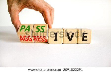 Passive or aggressive symbol. Businessman turns wooden cubes and changes the word passive to aggressive. Beautiful white background, copy space. Business, psychological passive aggressive concept.