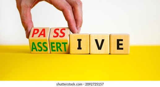 Passive or assertive symbol. Businessman turns wooden cubes and changes the word passive to assertive. Beautiful white background, copy space. Business, psychological passive assertive concept.
