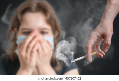 Passive smoking concept. Woman is covering her face from cigarette smoke. - Shutterstock ID 457207462