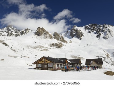 PASSO DEL TONALE, ITALY - MARCH 30: Skiers in front of mountain hut Malga-Valbiolo below the pass Contrabbandieri on March 30, 2015. Ski resort Passo Tonale