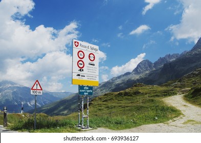 Passo Sluga ( Splügen Pass ) Marking The Boundary Between Italy And Switzerland. The Road Sign Indicating The Road Traffic Regulations.  