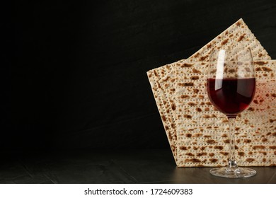 Passover matzos and glass of wine on black background, space for text. Pesach celebration