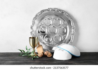 Passover Seder Plate With Kippah And Cup On Table Against White Background