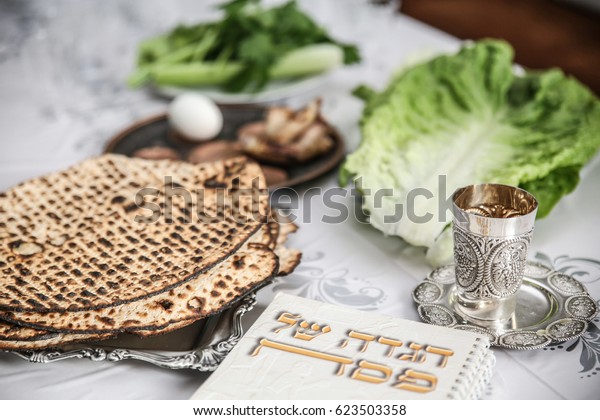Passover Seder Plate with The seventh\
symbolic item used during the seder meal on passover Jewish\
holiday.\
 (Kiddush cup, haggada, matzos, lettuce, an\
arm)