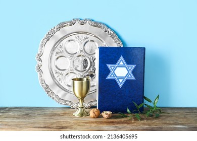 Passover Seder Plate With Torah And Cup On Table Against Color Background