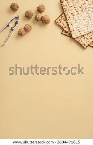 Passover-themed vertical image featuring matzah crackers, walnuts, and a nutcracker on a neutral background