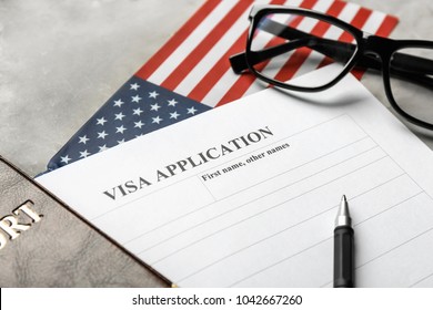 Passport, American Flag And Visa Application Form On Table. Immigration To USA