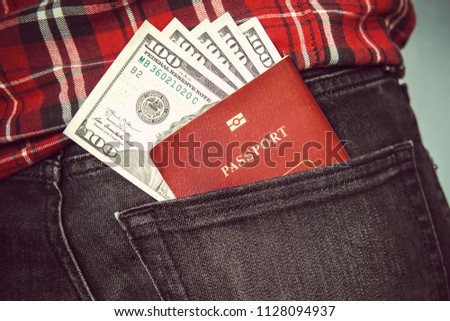 Passport in the back jeans pocket with American dollars. concept of travel. pocket money in my back pocket. out of pocket expenses. hundred dollars