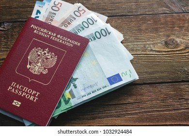 Passport and banknote euro on a wooden table - Shutterstock ID 1032924484