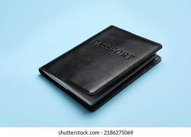 Passport In Black Leather Case On Light Blue Background