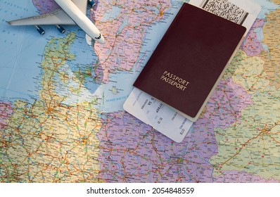 Passport With Boarding Pass And A Small Toy Airplane On A Travel Map. Plane Ticket, Trip Planning.