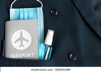 Passport Travel And Hand Sanitizer Spray And Blurred Surgical Mask In Suit Pocket With Copy Space. Tourism,holiday And Business Meeting Concept In New Normal Lifestyle After Covid-19 Pandemic.