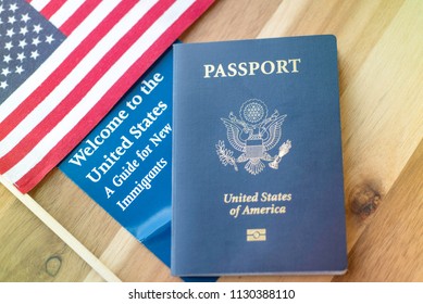 Passport Of USA (United States Of America) Next To A Guide For New Immigrants - Welcome To The United States And American Flag. Wooden Surface.