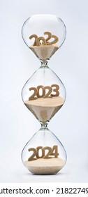 Past, Present And Future Concept. 3 Part Hourglass. Falling Sand Taking The Shape Of Years 2022, 2023 And 2024.