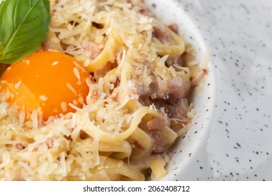 Pasta Carbonara. Spaghetti With Bacon, Parmesan, Cream Sauce And Egg Yolk. Macro Close-up Isolated On A White Round Plate. Mediterranean Gourmet Food.