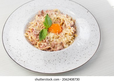 Pasta Carbonara. Spaghetti With Bacon, Parmesan, Cream Sauce And Egg Yolk. Macro Close-up Isolated On A White Round Plate. Mediterranean Gourmet Food.