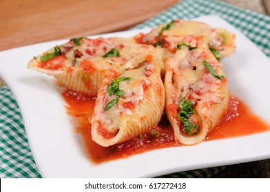 pasta conchiglioni shells stuffed meat mince with spinach and tomato sauce , Parmesan cheese, on a plate. Front view. 