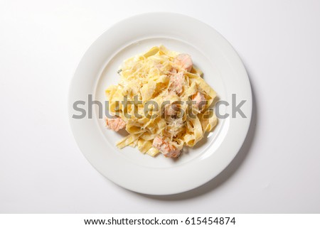 Pasta fettuccine alfredo with chicken, parmesan and parsley on white plate. Italian cuisine. Close up