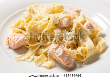 Pasta fettuccine alfredo with chicken, parmesan and parsley on white plate. Italian cuisine. Close up