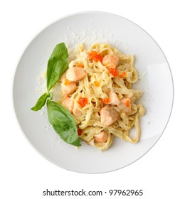 Pasta fettuccine with salmon and caviar on a white dish isolated on a white background. Top view.