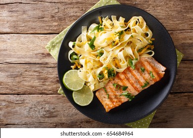 Pasta Fetuccini With Cheddar Cheese And Grilled Salmon On A Plate Close-up. Horizontal View From Above
