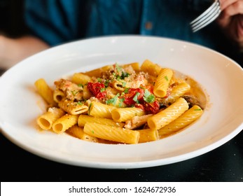 Pasta With Fresh Tomato Sauce Parmesan And Basil Rigatoni Noodles In White Bowl Plate And Person Eating With Fork