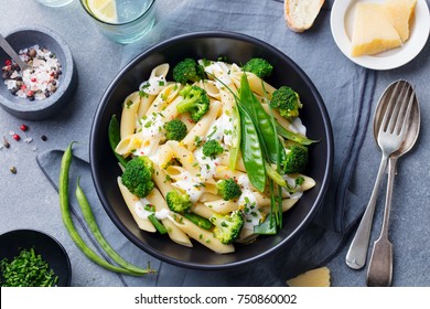 Pasta with green vegetables and creamy sauce in black bowl on grey stone background. Close up. - Powered by Shutterstock