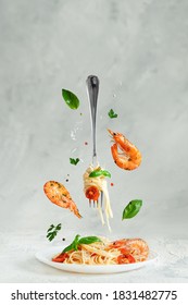 Pasta Linguine With Prawns And Fork Flying Over The Dish. Creative Still Life. Italian Food.