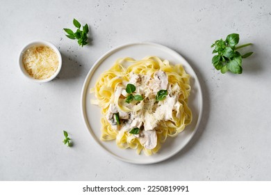 Pasta mushrooms with chicken, parmesa and basil on white backgroun, copy space, top view - Shutterstock ID 2250819991