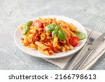 Pasta Penne Bolognese in white plate on light background. Bolognese sauce is classic italian cuisine dish. Popular italian food.