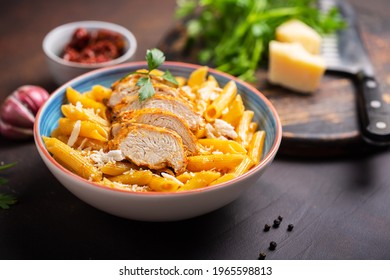 Pasta Penne With Cajun Sauce And Fried Chicken On A Dark Background