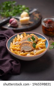 Pasta Penne With Cajun Sauce And Fried Chicken On A Dark Background