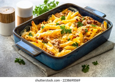 Pasta penne with chicken meat, cheese and creamy sauce in the pan. Mac and cheese. Baked dish.