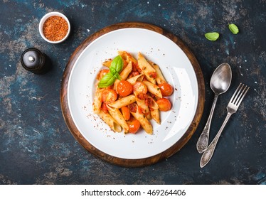 Pasta Penne With Tomato Sauce, Fresh Basil And Roasted Tomatoes. Old Painted Dark Plywood Background, Top View, Horizontal Composition