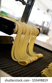 Pasta Plant And Pasta Production Stages. Macaroni Cutting Operation On An Industrial Machine.