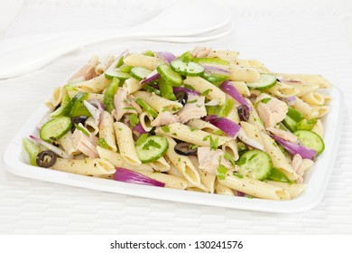 A Pasta Salad With A Basil Pesto Dressing, Tuna, Olives, Red Onion, Cucumber And Green Pepper, Sprinkled With Parsley.