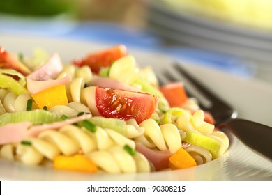 Pasta salad with leek, cherry tomato, yellow bell pepper and ham garnished with chives (Selective Focus, Focus on the tomato in the front) - Powered by Shutterstock