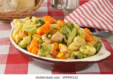 A Pasta Salad On A Picnic Table With Chicken And Vegetables