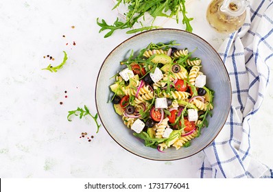 Pasta Salad With Tomato, Avocado, Black Olives, Red Onions And Cheese Feta. Mediterranean Cuisine. Top View, Overhead, Flat Lay