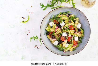 Pasta Salad With Tomato, Avocado, Black Olives, Red Onions And Cheese Feta. Mediterranean Cuisine. Top View, Overhead, Flat Lay