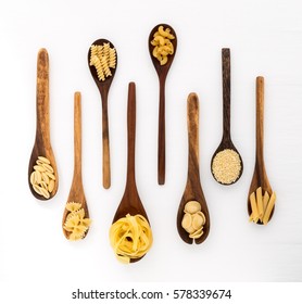 Pasta selection of penne, gnocci, rigatoni, casarecce, fiorelli, pasta Farfalle, pasta A Riso, Orecchiette Pugliesi, Gnocco Sardo and Farfalle in wooden spoons over white background - Powered by Shutterstock