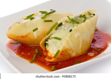 Pasta shells stuffed with swiss chard, ricotta, mozzarella and parmesan cheeses with tomato sauce and chives.