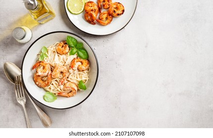 Pasta Spaghetti With Grilled Shrimp And Creamy Alfredo Sauce Served With Fresh Basil Leaves. Light Gray Background, Top View