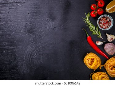 Pasta Spaghetti with Ingredients for cooking pasta on a on Black Background, top view. Copy space for Text. selective focus. - Shutterstock ID 601006142
