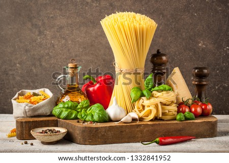 Pasta, spaghetti and ingredients on wooden table